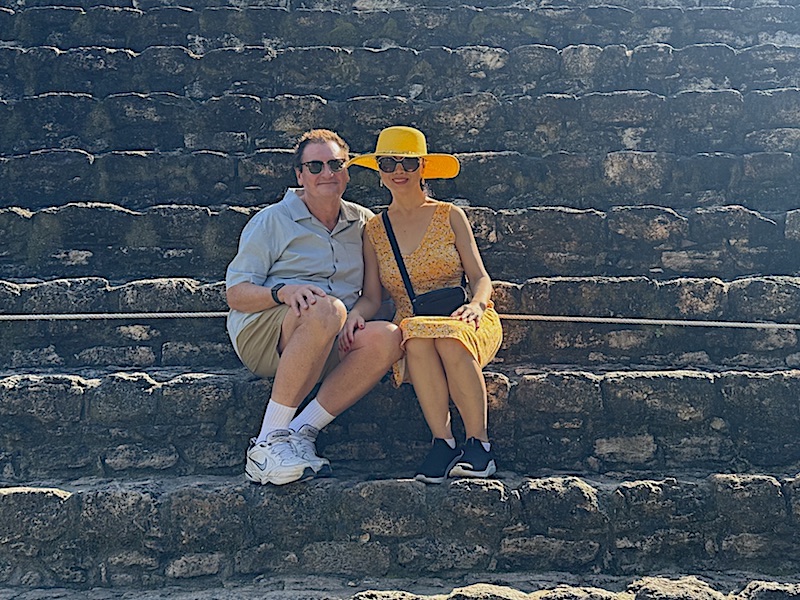 author Barry Kramer and his wife, Liping, sitting on the steps of Temple 24 at Chacchoben