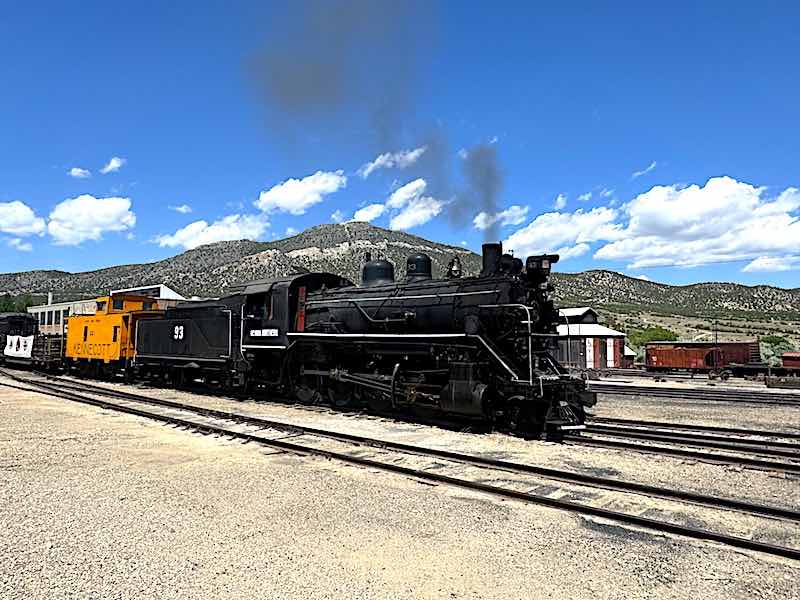 Steam Engine 93 pulling a caboose, open-air passenger car, and passenger coach at the Northern Nevada Railway Museum