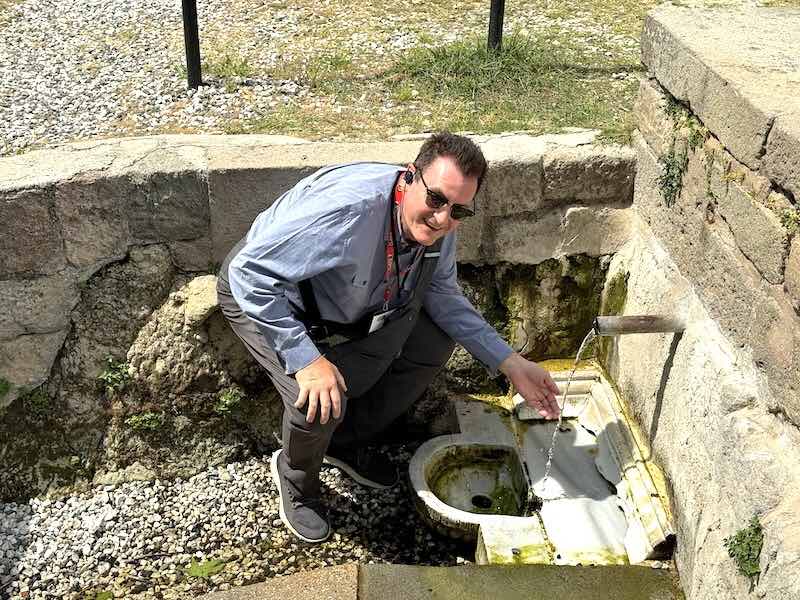 Sampling water from the sacred healing spring of the Asclepieion